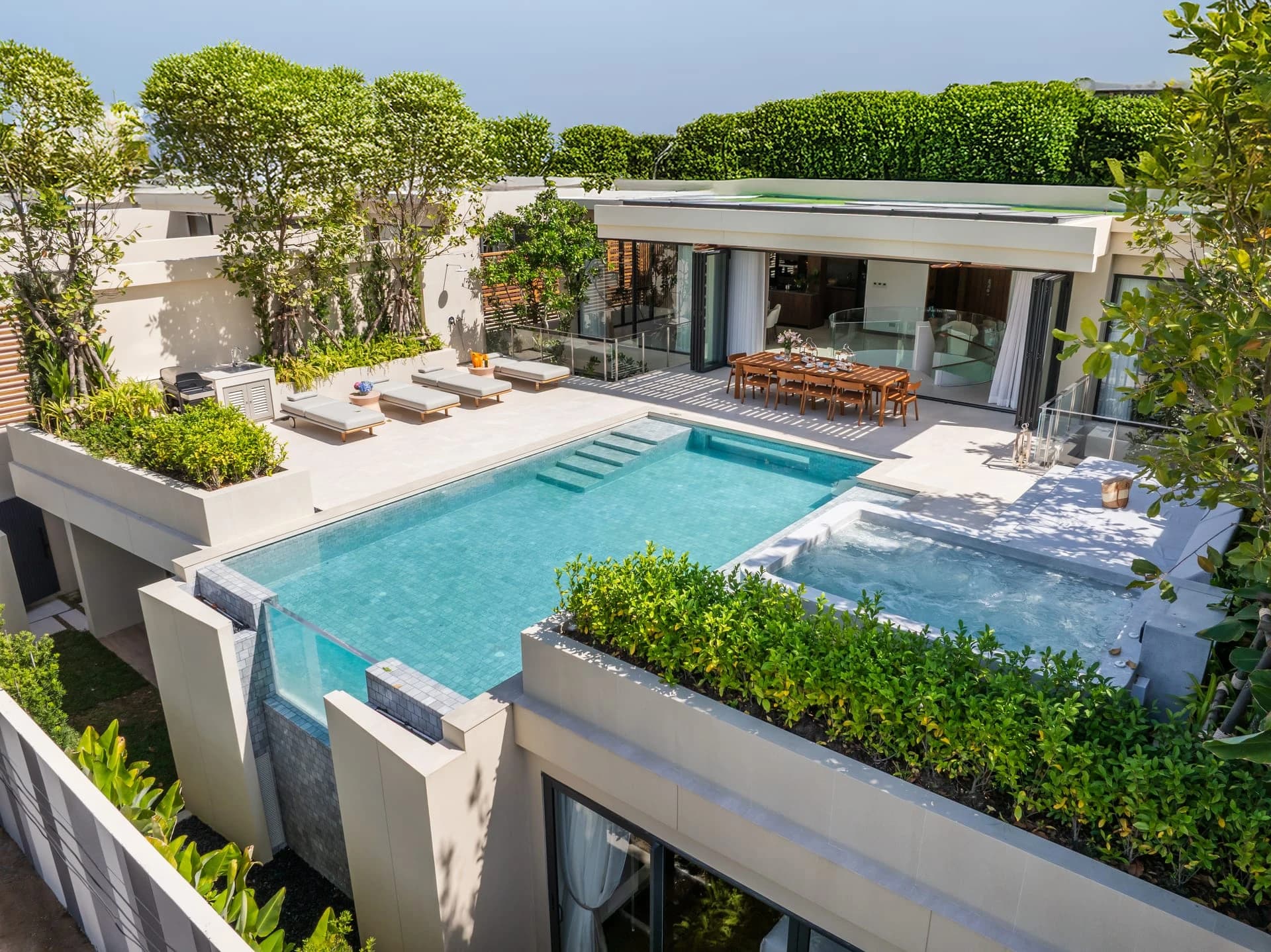A finished Aegir villa: the glass-edged pool, the raised jacuzzi deck and planted parapets of the living level