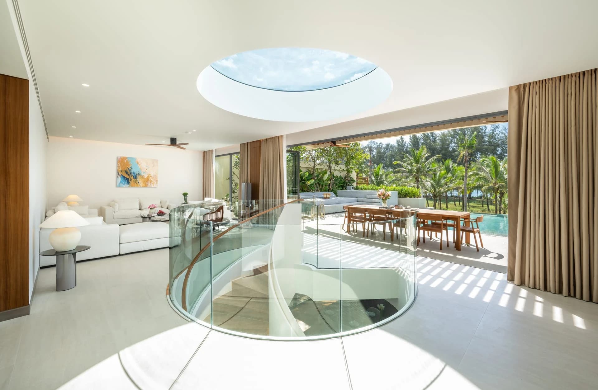Built: the upper living room under the round skylight, the glass balustrade around the spiral stair